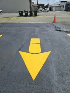 Fresh yellow directional arrow and parking lot striping completed by Peach State Stripe